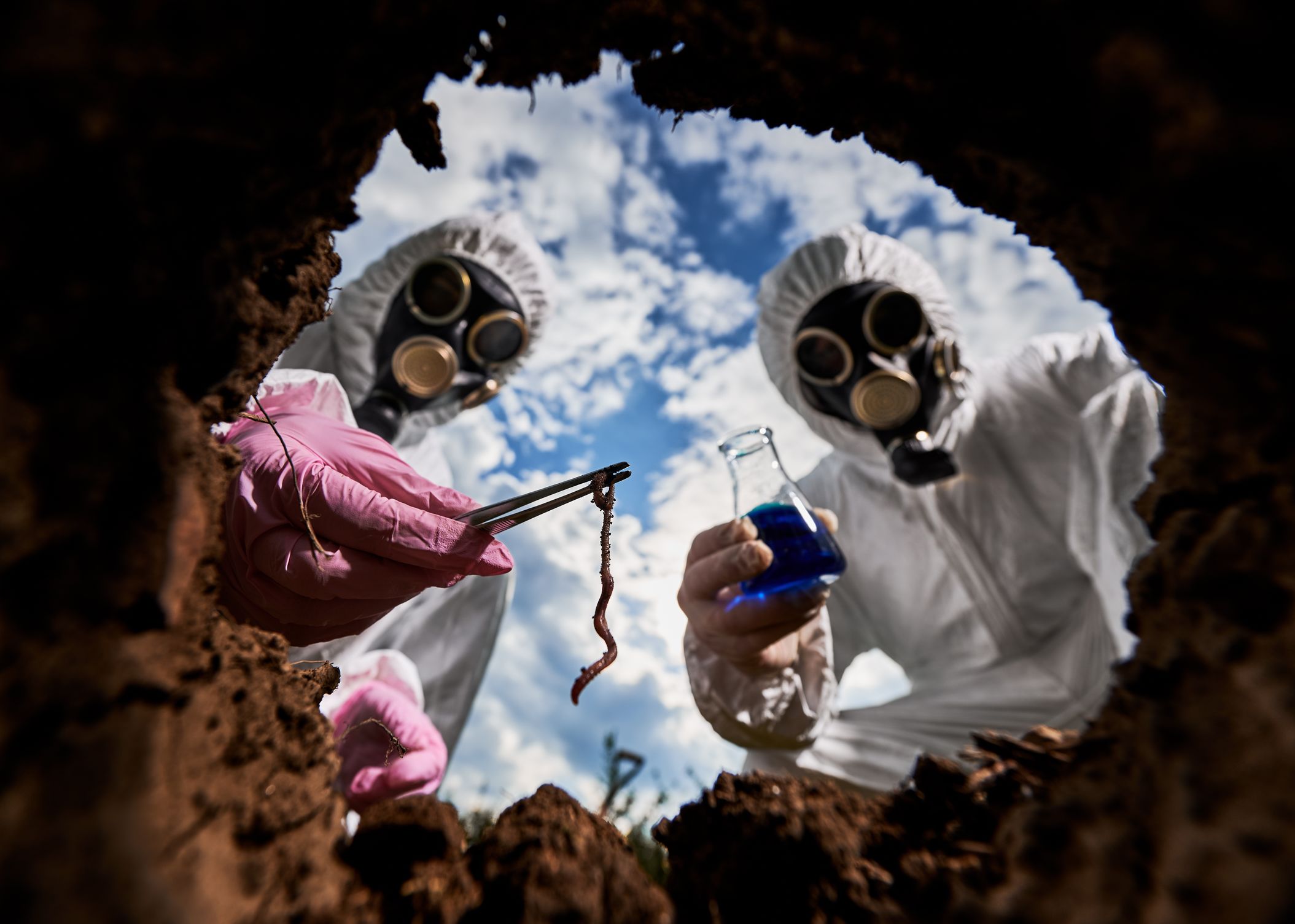 Pessoas mascaradas manipulando resíduos perigosos