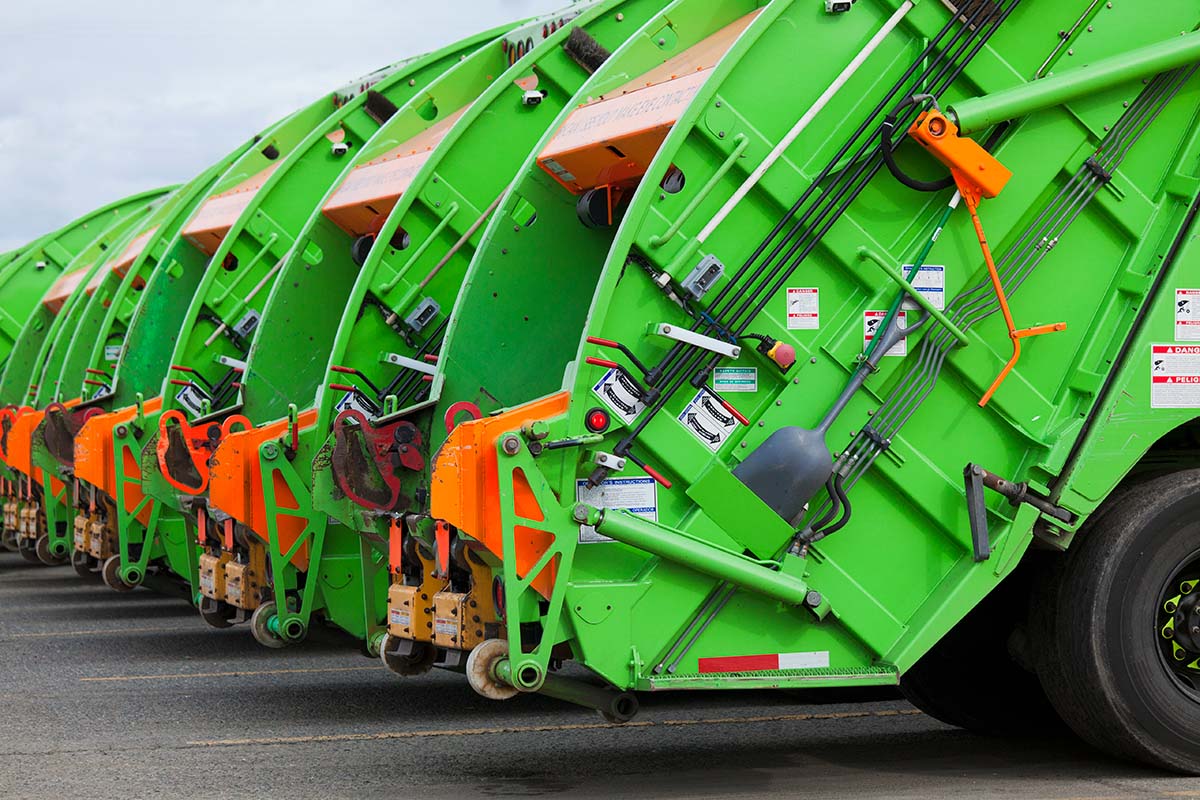 Fila de caminhões de coleta de resíduos sólidos com sistema hidráulico, utilizados para transporte de lixo urbano e industrial