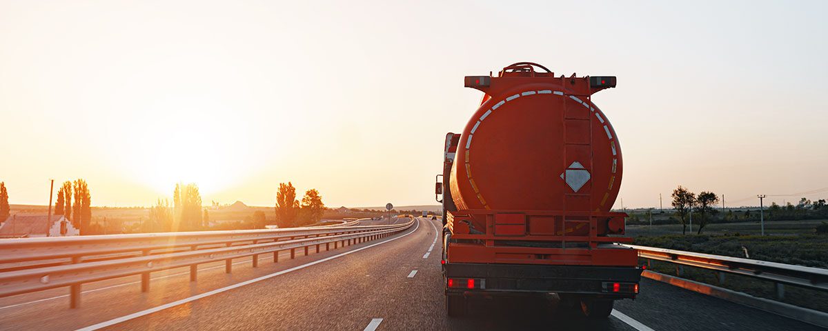 Caminhão-tanque transportando resíduos perigosos ao entardecer em rodovia, representando controle e rastreabilidade ambiental exigidos pelo CNORP do Ibama