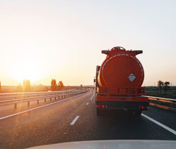 Caminhão-tanque transportando resíduos perigosos ao entardecer em rodovia, representando controle e rastreabilidade ambiental exigidos pelo CNORP do Ibama