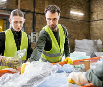 Trabalhadores realizando triagem de resíduos recicláveis conforme diretrizes da NBR 10004, norma que classifica resíduos sólidos para destinação ambientalmente adequada.