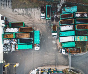 Vista aérea de centro de triagem e tratamento de resíduos sólidos, com caçambas organizadas para separação e reciclagem, representando o uso de tecnologias sustentáveis na gestão de resíduos.