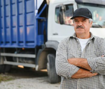 Imagem de um motorista de caminhão de transporte de resíduos, com expressão confiante, posicionado à frente de um caminhão de coleta. Representa a importância da logística e do controle no transporte de resíduos sólidos, seguindo normas ambientais e garantindo segurança e eficiência. Ideal para conteúdos relacionados a CTR (Controle de Transporte de Resíduos), gestão de resíduos industriais, sustentabilidade e regulamentação ambiental.