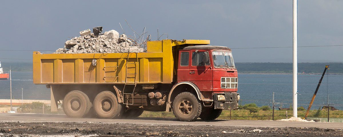 Caminhão transportando entulho e resíduos da construção civil para destinação ou disposição final ambientalmente adequada. Gestão de resíduos sólidos e sustentabilidade na construção.