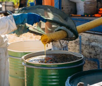 Profissional manipulando substância líquida com equipamento de proteção, ilustrando em quais casos é obrigatória a emissão da FISPQ — Ficha de Informação de Segurança de Produto Químico.