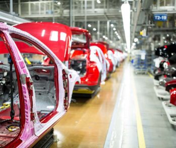 Produção em uma indústria automobilística, ilustrando o ambiente de manufatura padronizado por normas ISO.