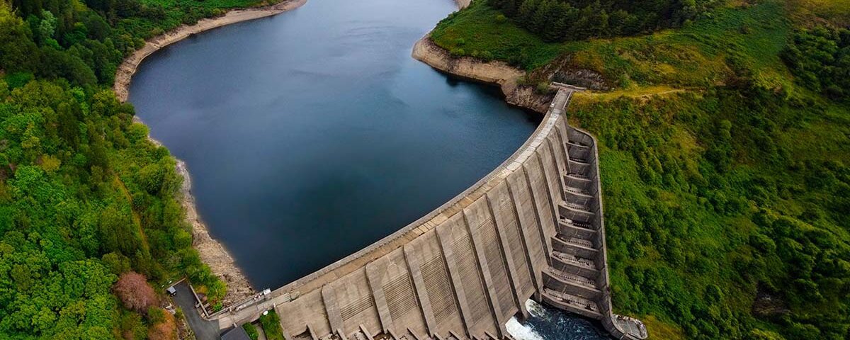Imagem aérea de barragem em meio à vegetação, representando a gestão integrada e sustentável dos recursos hídricos conforme diretrizes da Lei 9.433/97.