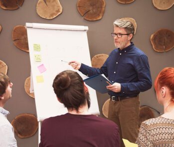 Instrutor conduz treinamento sobre educação ambiental para colaboradores, reforçando a importância da Lei 9795/99 e práticas sustentáveis nas empresas.