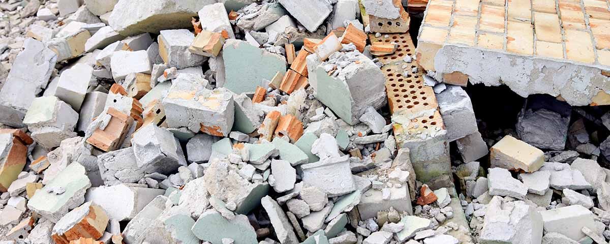 Entulho de construção civil com restos de blocos, tijolos e concreto quebrado, representando resíduos sólidos e descarte correto de materiais de obra.