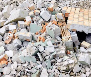 Entulho de construção civil com restos de blocos, tijolos e concreto quebrado, representando resíduos sólidos e descarte correto de materiais de obra.