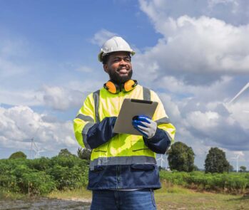 Profissional utiliza um tablet para o controle da documentação de fornecedores em um projeto de energia renovável.