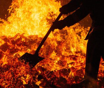 Profissional operando incinerador com chamas intensas durante o processo de incineração de resíduos sólidos. Gestão de resíduos, tratamento térmico e avaliação das vantagens e desvantagens da incineração do lixo.