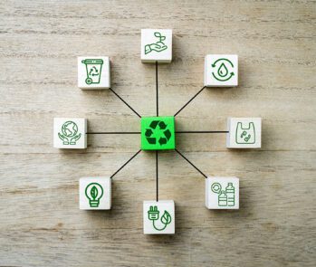 Representação conceitual de um sistema de gestão ambiental (SGA) com ícones relacionados à sustentabilidade, reciclagem, energia limpa e conservação de recursos naturais, dispostos em blocos conectados. A imagem destaca a importância da integração de práticas sustentáveis nas organizações.